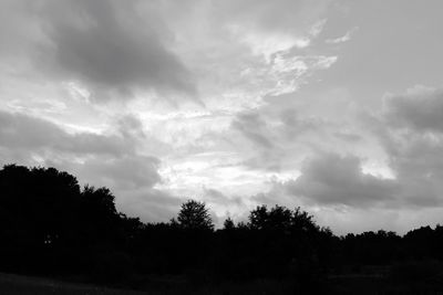 Silhouette trees against cloudy sky