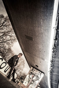 Reflection of man standing on built structure