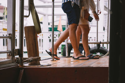 Low section of friends walking on boat