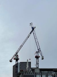 Low angle view of crane against sky