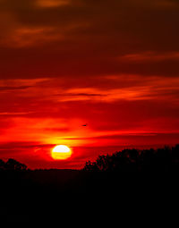 Scenic view of silhouette trees against romantic sky at sunset