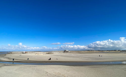 Scenic view of beach against blue sky