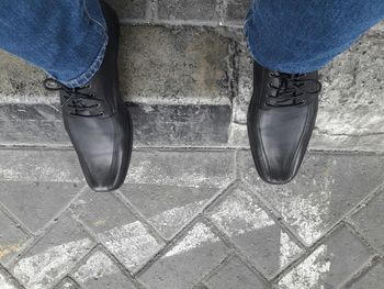 Low section of man standing on sidewalk