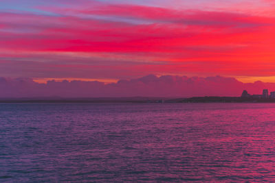 Scenic view of sea against dramatic sky during sunset