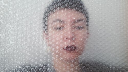 Close-up of woman seen through bubble bag