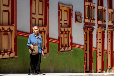 Rear view of woman standing against building