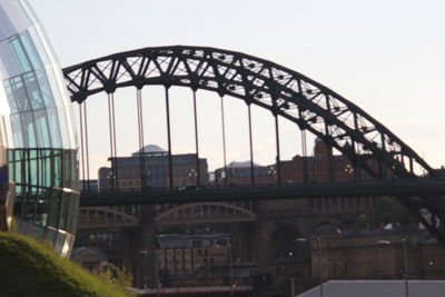 Bridge over river in city against clear sky