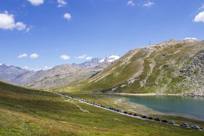 View of cars on road by mountain against sky