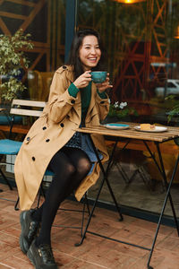 Portrait of young woman sitting on chair