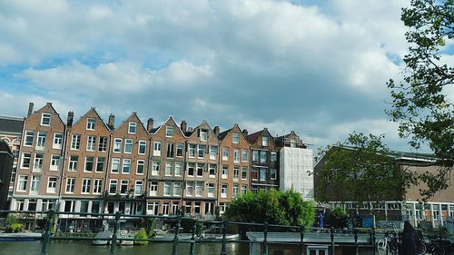 Low angle view of buildings against cloudy sky