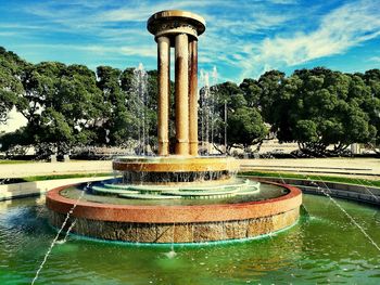 Fountain in swimming pool against sky