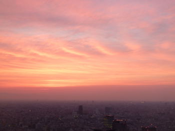 View of cityscape against cloudy sky during sunset