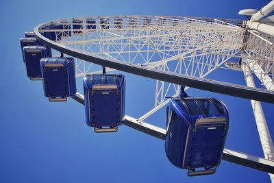 Low angle view of ferris wheel against clear blue sky