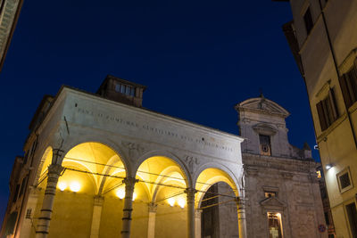 Low angle view of illuminated building against clear sky at night