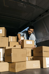 Delivery man picking up package from van