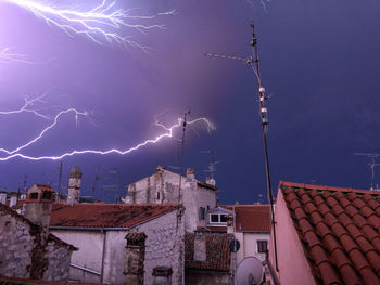 Low angle view of buildings in city against a thunder