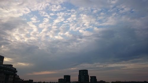 Low angle view of buildings against cloudy sky