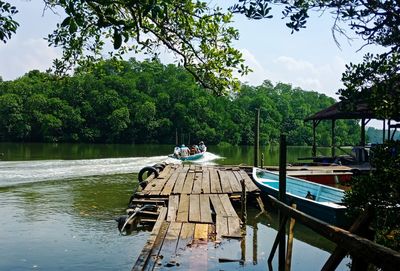 Boat moored on lake against sky