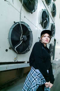 Side view of young woman standing in car