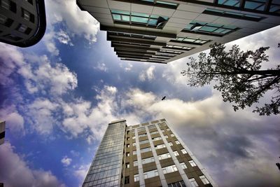 Low angle view of modern building against cloudy sky