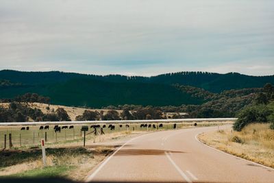 Road leading towards mountain against sky