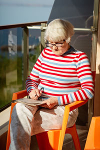 Portrait of woman sitting on chair at home