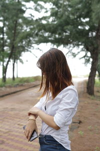 Woman standing against tree