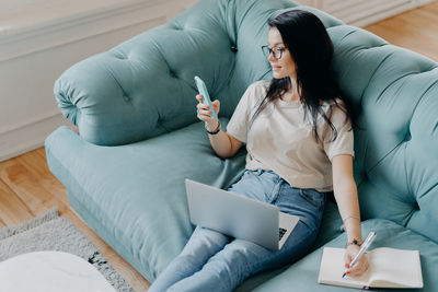 Young woman using mobile phone at home