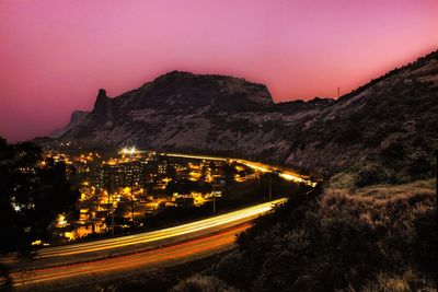 Light trails on mountain against clear sky at night