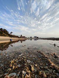 Surface level of stones on beach against sky