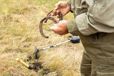 Man with electronic metal detector device working on outdoors.