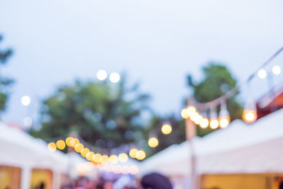 Low angle view of illuminated lights on street against sky