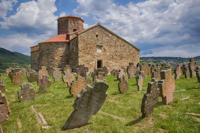 Old ruins of building on field against sky