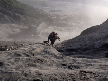 High angle view of man climbing on snow covered mountain