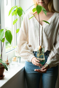 Midsection of woman holding potted plant