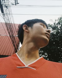 Portrait of young man looking away against sky