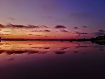 Scenic view of sea against dramatic sky during sunset