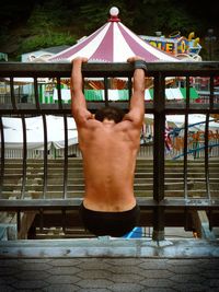 Rear view of shirtless boy in water