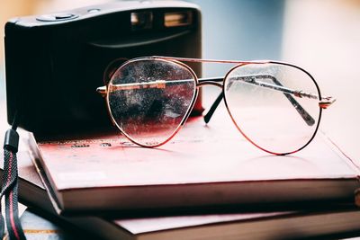 Close-up of eyeglasses and camera on diary