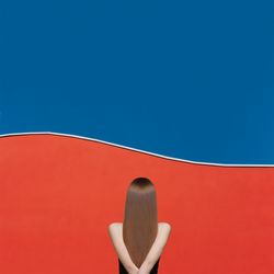 Rear view of woman against blue sky