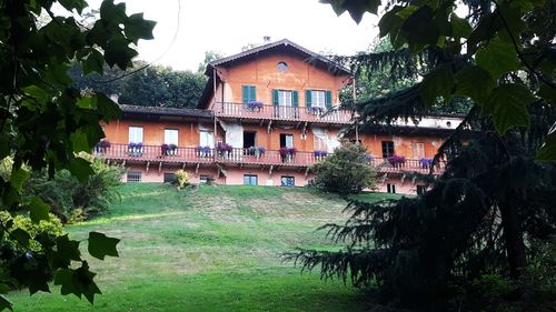 Houses by trees and buildings against sky