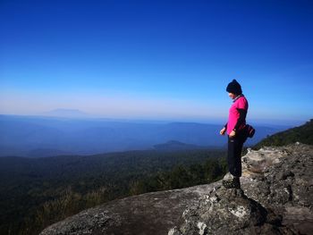 Full length of man standing on rock against sky