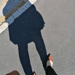 Low section of man standing on road