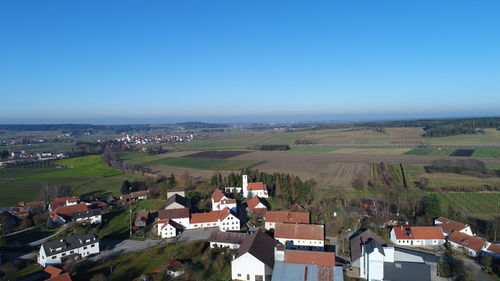 High angle view of houses against clear blue sky