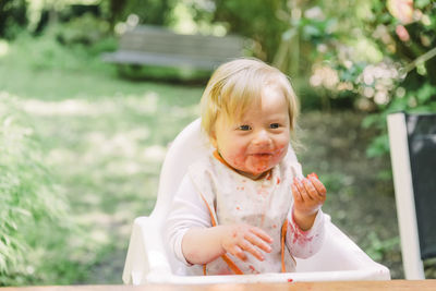 Cute girl eating while sitting outdoors