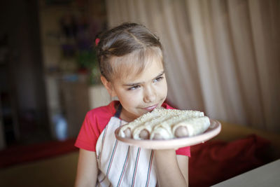 Portrait of girl holding camera at home