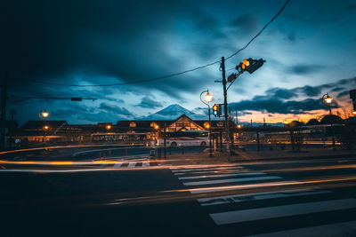 Light trails on road against sky at dusk