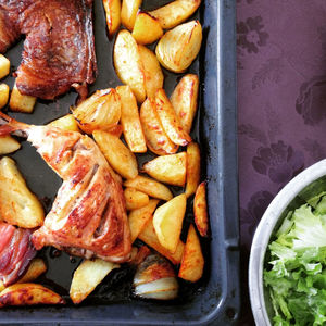 Directly above view of roasted chicken with potatoes in tray on table