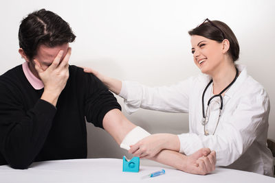 Young couple looking away while sitting on table
