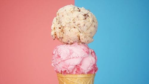 Close-up of ice cream cone against pink background